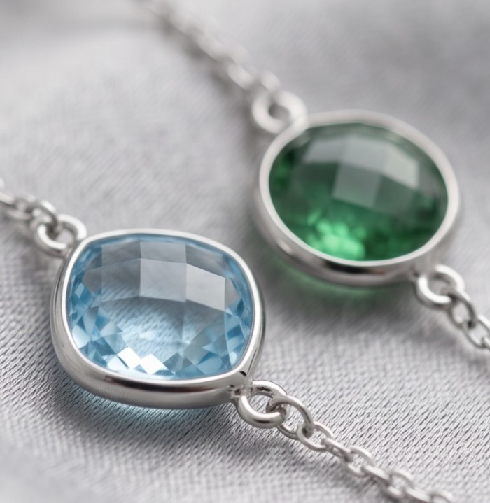 Infinity 18.5 carat Authentic Multigems Rhodium over .925 Sterling Silver handcrafted Statement necklace - Close-up of blue and green gemstone bracelets on a soft surface
