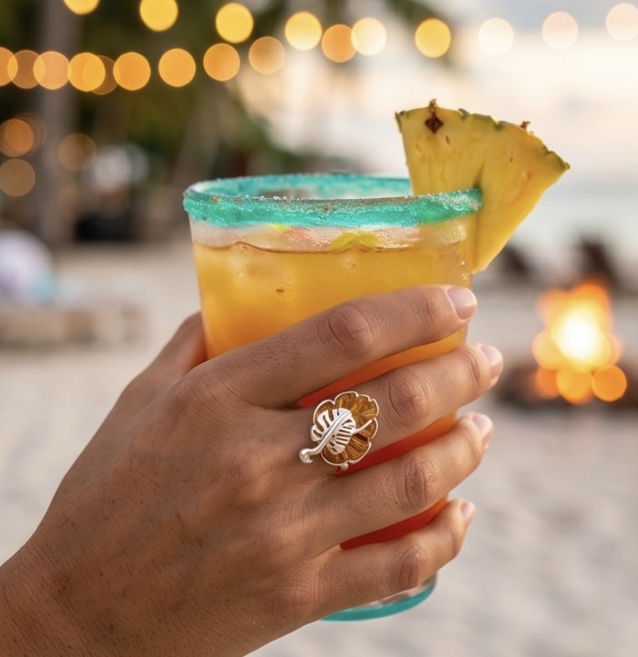 Golden Leaf Authentic carved Baltic Amber .925 Sterling Silver handcrafted ring; s. 7 - Worn on hand with tropical drink, showcasing carved amber ring.