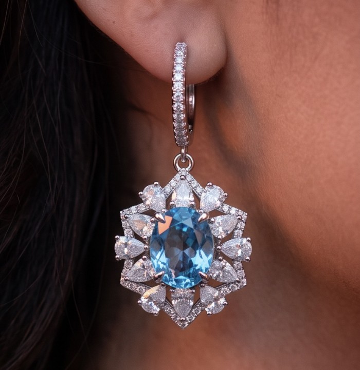 Atlantica 5.7 carat Swiss Blue Topaz .925 Sterling Silver Handcrafted Statement earrings - Close-up of earring with blue topaz stone worn on ear