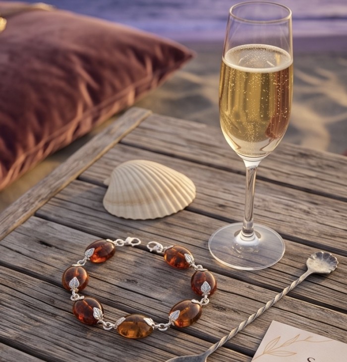 Golden Baltic Amber .925 Sterling Silver dipped in rhodium handamde Bracelet - Bracelet with amber and silver on table by champagne and shell, top view