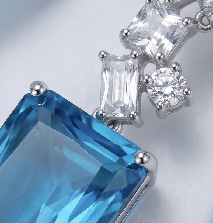 FINE Art 15.8 carat Swiss Blue Topaz rhodium over .925 Sterling Silver Handcrafted Statement earrings - Close-up of blue topaz and clear stones in silver setting.