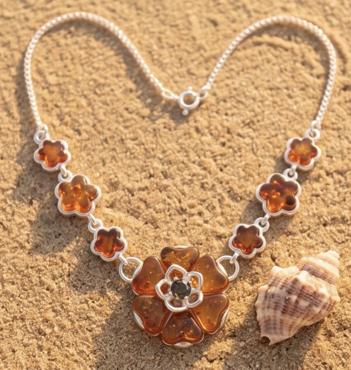 Floral design - natural Golden carved Baltic Amber .925 Sterling Silver handcrafted necklace - Floral Baltic Amber necklace on sand with shell, top view.