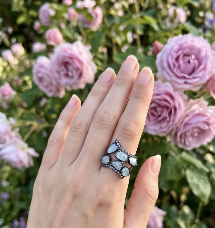 Blue Cascade 7.5 carat Rainbow Moonstone black rhodium over .925 Sterling Silver handmade ring s. 7 - Moonstone ring worn on hand, pink roses in background