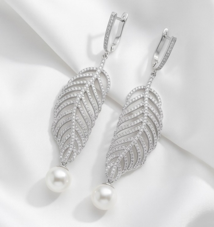 BLOOMING BEAUTY Genuine Pearl 0.2 CARAT lab grown Diamond rhodium over .925 Sterling Silver handcrafted Statement Earrings - Front view of pearl and diamond leaf earrings on white fabric.