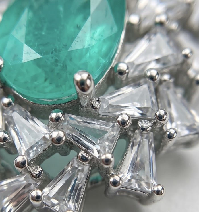 Isabella 3.2 carat oval cut Emerald .925 Sterling Silver Perfectly handcrafted pendant - Close-up of emerald and silver setting with clear triangular stones.