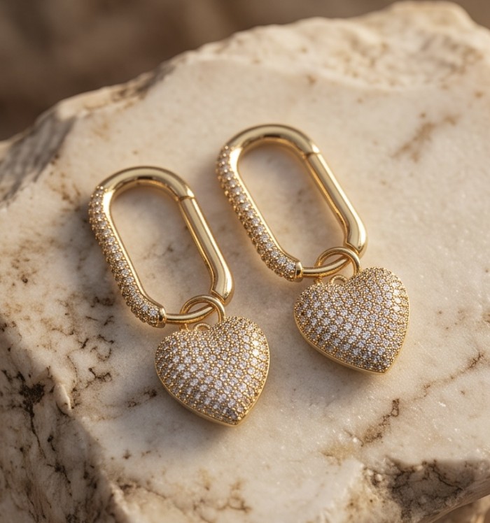 Endless Love - 1.7 carat pave White Topaz .925 Sterling Silver dipped in 18K Gold handmade Earrings - Close-up of gold heart-shaped earrings on marble surface.