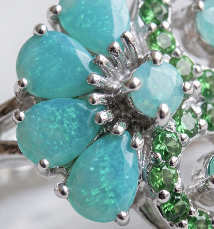 Elizabeth oval cut 4.8 carat Colombian Emerald .925 Sterling Silver dipped in Rhodium handcrafted Ring size 9 - Close-up of silver jewelry with blue and green gemstones.
