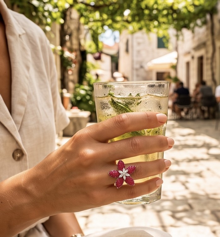 Scarlett mystery setting 9.7 ctw Mozambique Ruby .925 Sterling Silver dipped in rhodium handcrafted Statement Ring size 6 - Ruby flower ring worn on hand holding a drink in sunlight.