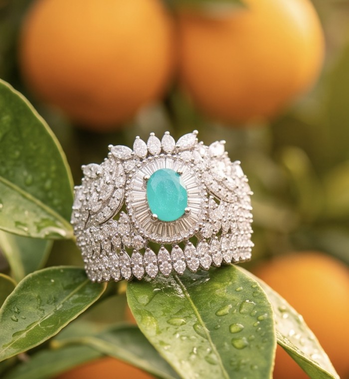 Elizabeth oval cut 2.2 carat Colombian Emerald .925 Sterling Silver dipped in Rhodium handcrafted Ring size 7 - Front view of emerald and diamond bracelet on tree branch with oranges.