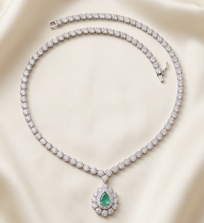 Estelle - Authentic 7.9 carat COLOMBIAN EMERALD .925 Sterling Silver handcrafted necklace - Necklace with emerald pendant on beige background, top view.