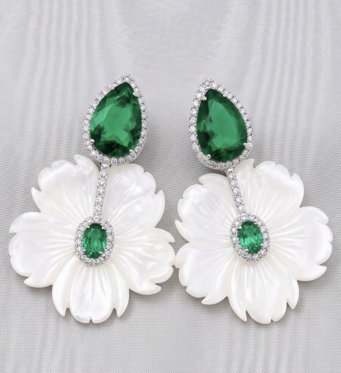 Summer Flowers Blister Pearl Blue Topaz Rhodium over .925 Sterling Silver handcrafted Earrings - Close-up of floral earrings with green stones on a textured background