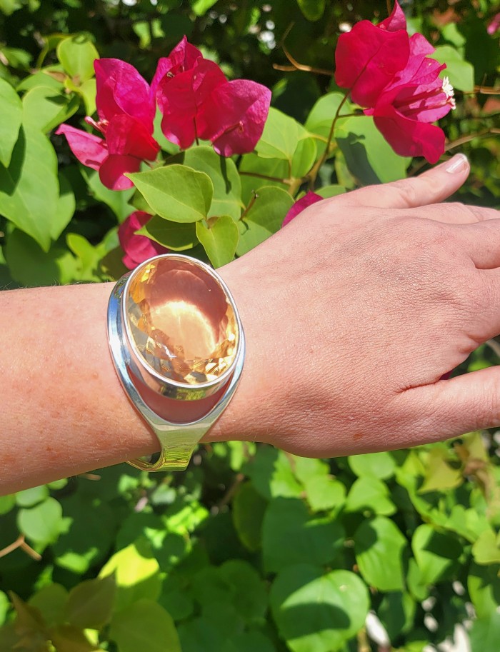 Simplicity 85.5 carat Genuine Lemon Quartz handcrafted .925 Sterling Silver Bracelet / Cuff - Worn on hand, large lemon quartz ring with pink flowers in background.