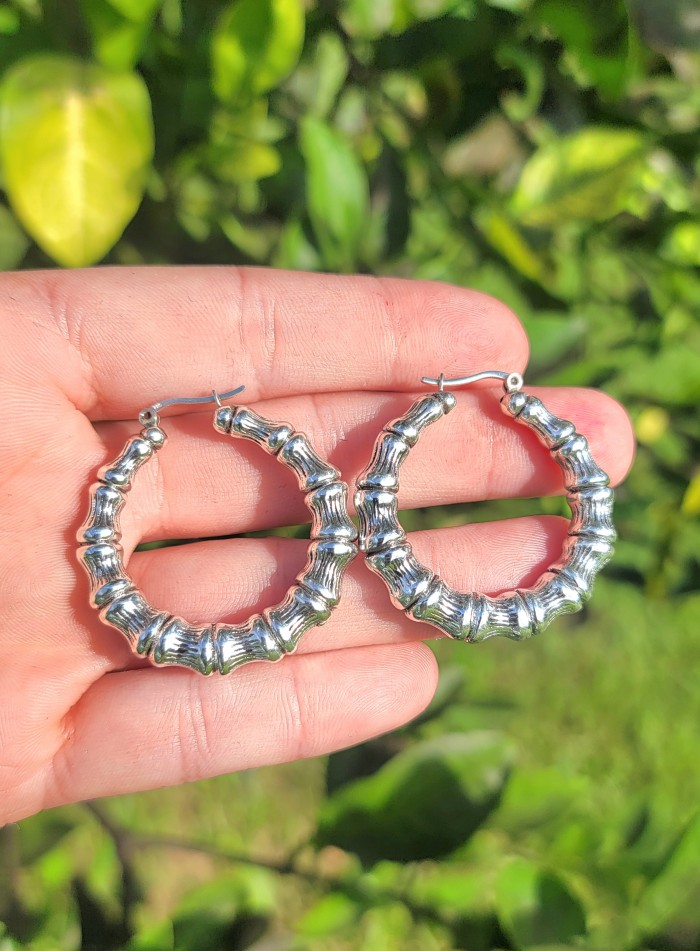 Huge - Bamboo Tree design .925 Sterling Silver handmade Bali made Earrings - Hand holding silver bamboo-design hoop earrings in natural light.